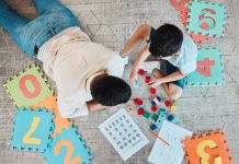 Building blocks, above or father with kid on the floor for learning, education or child development at home. Family, play or dad enjoying bonding time in living room with boy or toys doing homework.